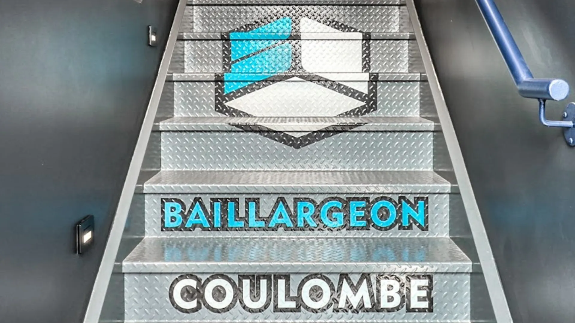 Escalier intérieur en acier strié orné du logo Baillargeon Coulombe