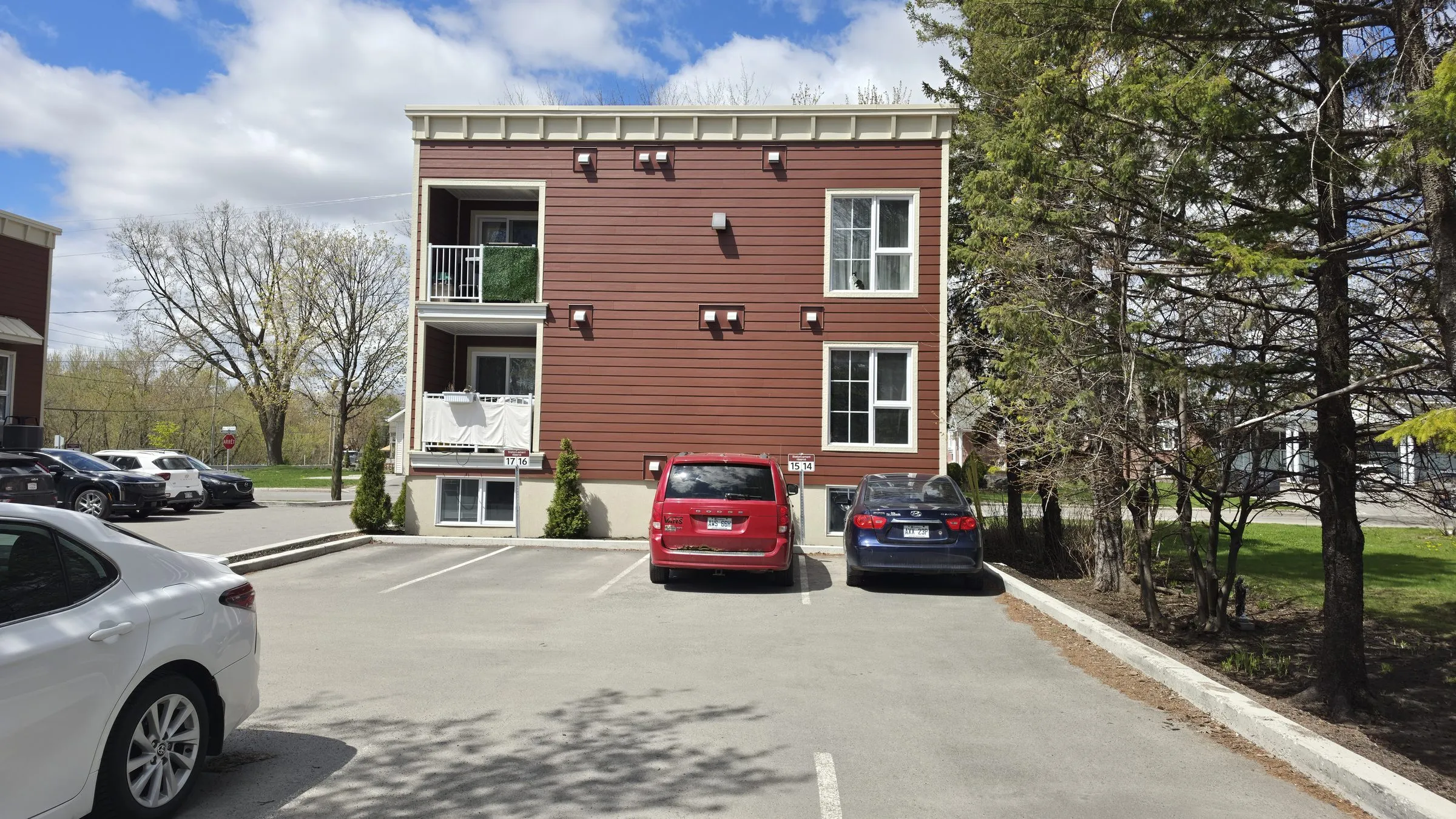 Vue arrière d'un bâtiment de logements et de son stationnement, à la livraison