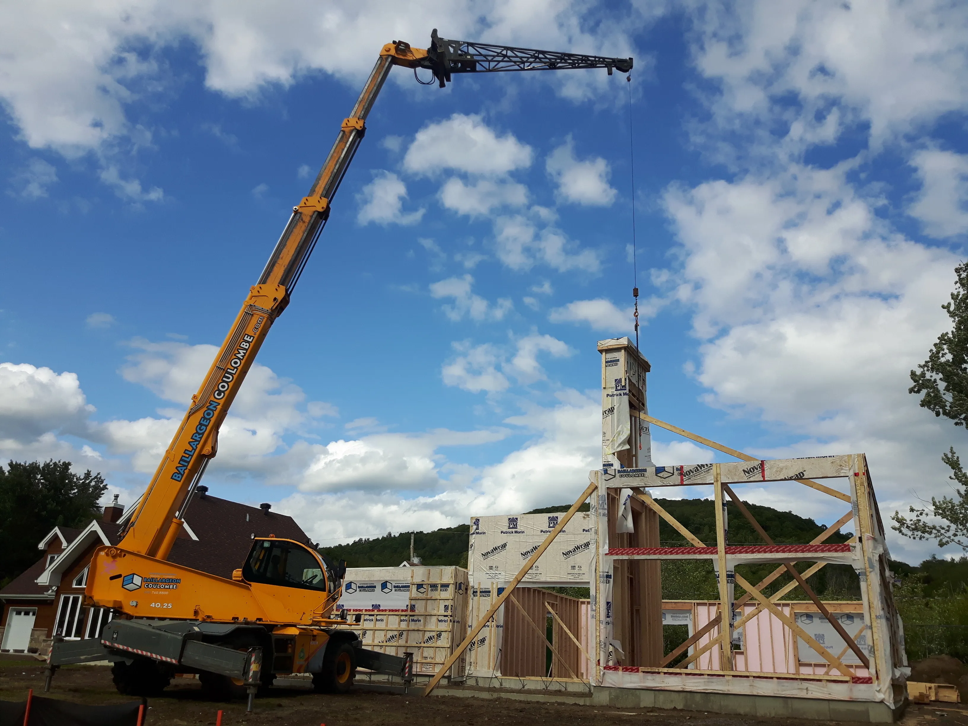 Camion télescopique Baillargeon Coulombe levant une cheminée préfabriquée