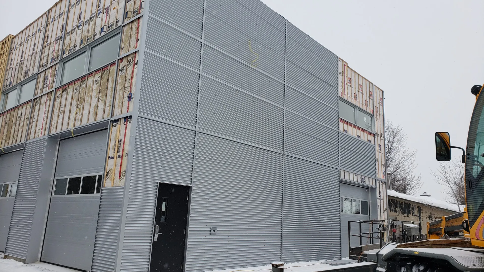 Pose du parement métallique gris sur la façade arrière