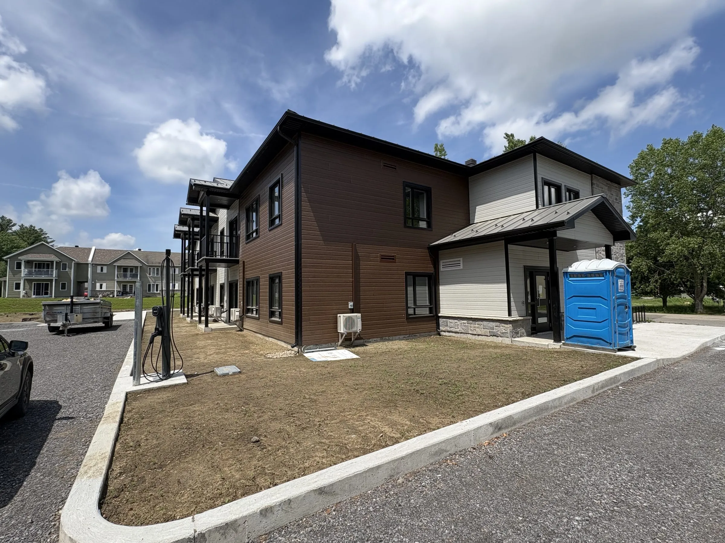 Second immeuble en parement brun et pierre claire, vu de l'entrée du site