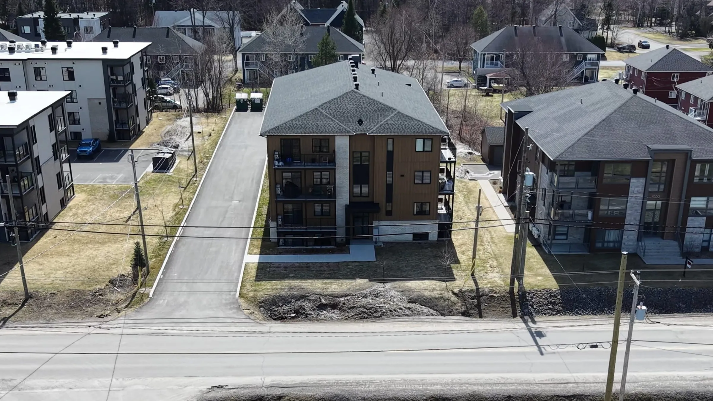 Vue aérienne large de l'immeuble entouré des bâtiments voisins, la rue au premier plan