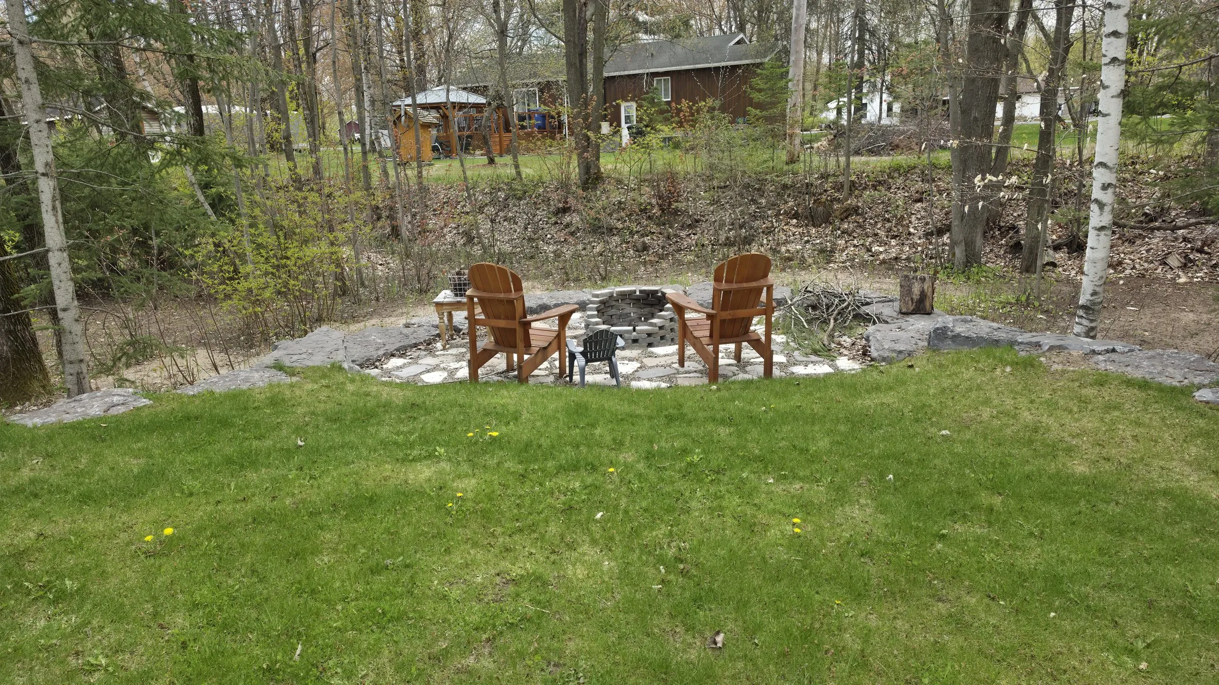 Foyer extérieur et chaises Adirondack aménagés à l'arrière du terrain