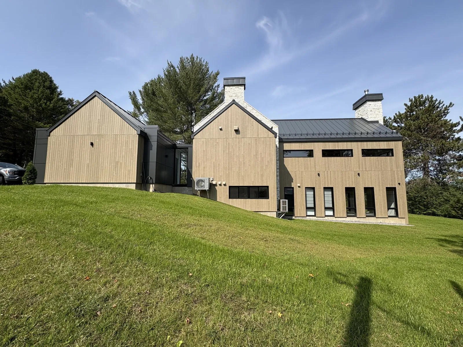 Volumes en bois et cheminées en pierre, façade arrière