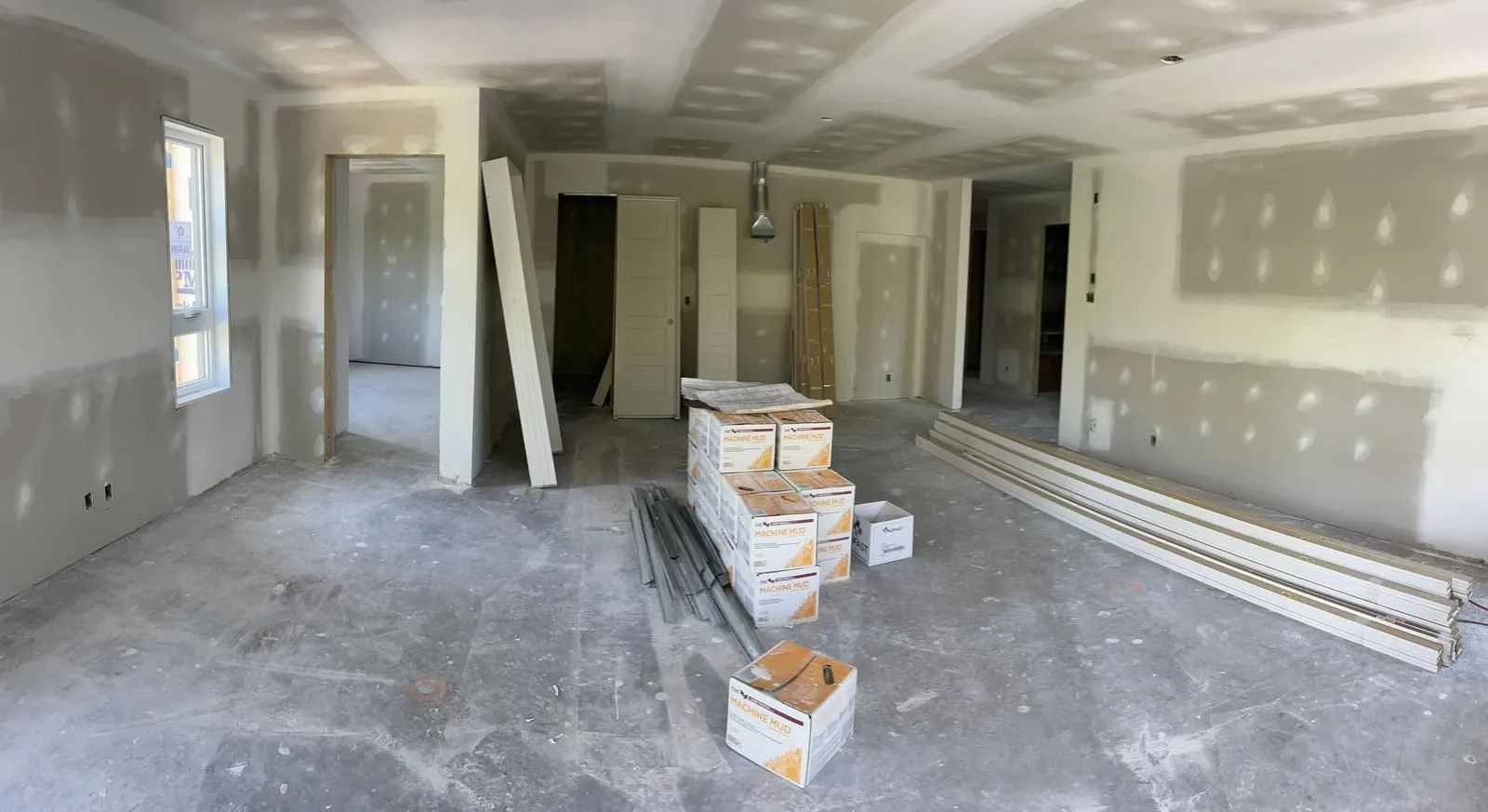 Intérieur d'un logement, cloisons de gypse posées et matériaux de finition entreposés au sol
