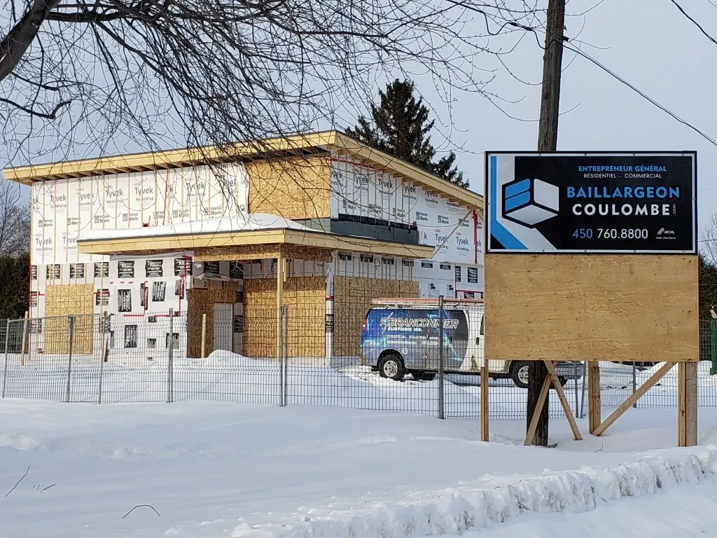 Structure montée en hiver, panneau de chantier Baillargeon Coulombe en avant-plan