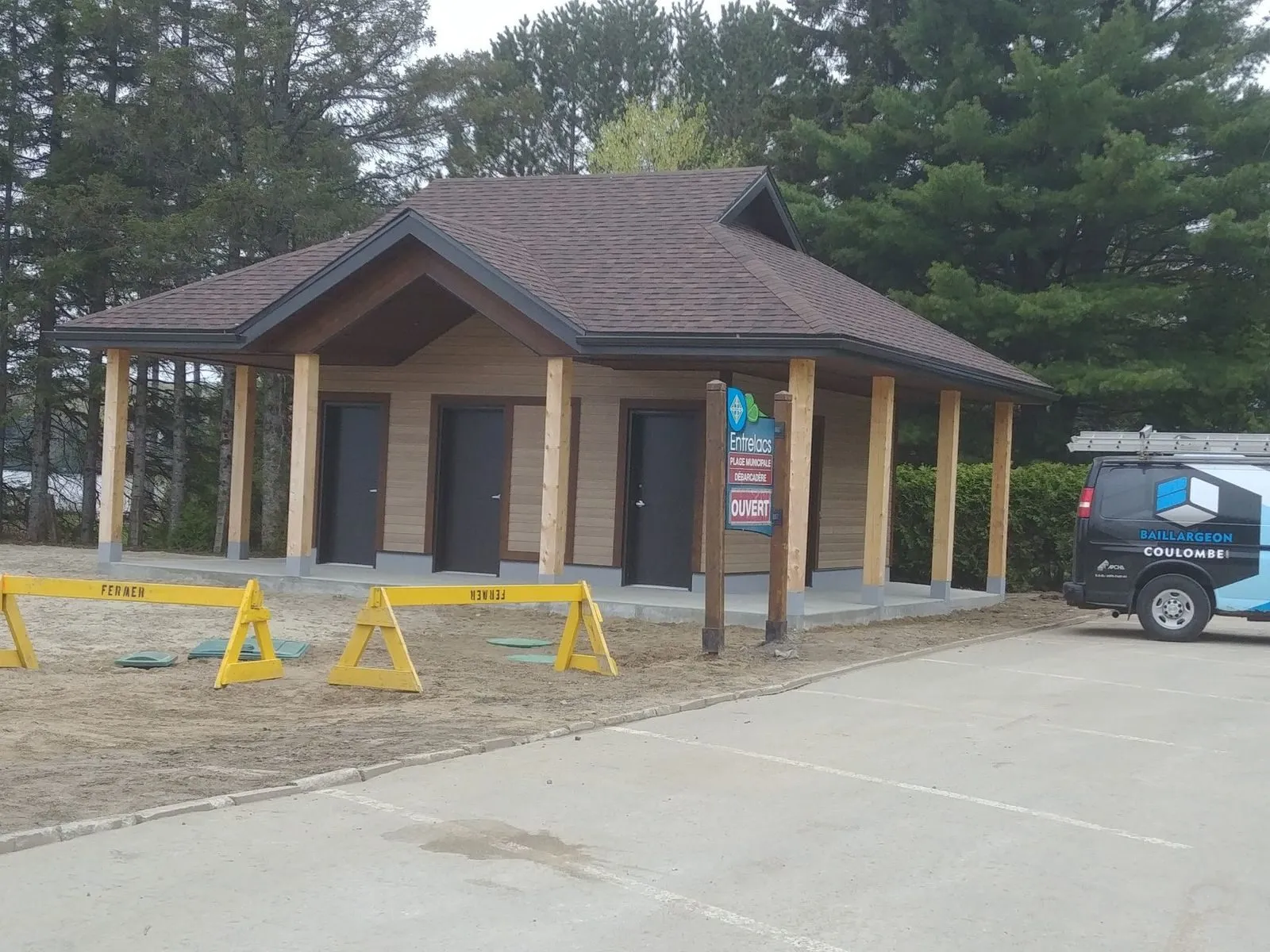 Le pavillon vu depuis le stationnement : volume compact sous toit pentu, ceinturé de sa galerie à colonnes