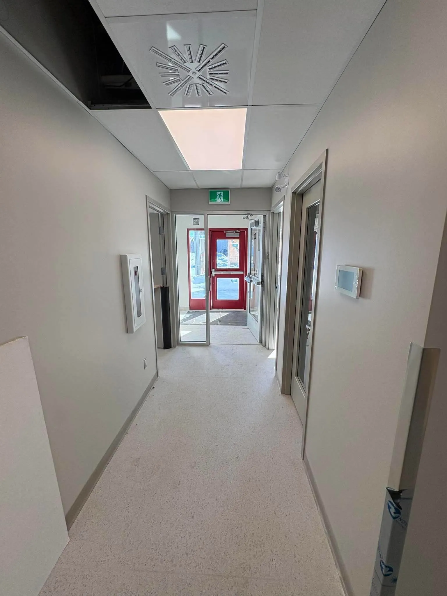 Corridor principal du CPE menant à la porte d'entrée rouge
