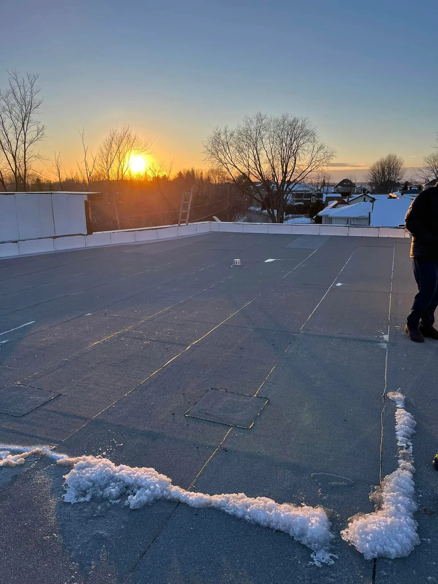 Le toit plat qui accueille la terrasse commune, photographié en cours de chantier au coucher du soleil