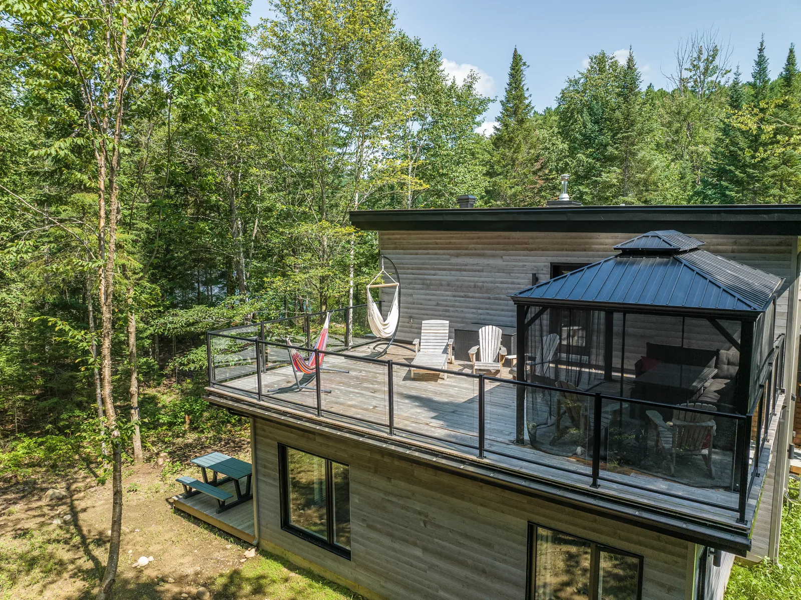 Le chalet livré, intégré à la forêt mature - vue depuis la terrasse arrière